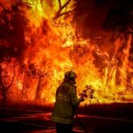 Fire and Rescue use a hose in an effort to extinguish a bushfire as it burns near homes on the outskirts of the town of Bilpin on Dec. 19, 2019 in Sydney, Australia.