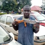 Geoffrey Ayuba rike da bindigar AK-47 da aka samu a motarsa